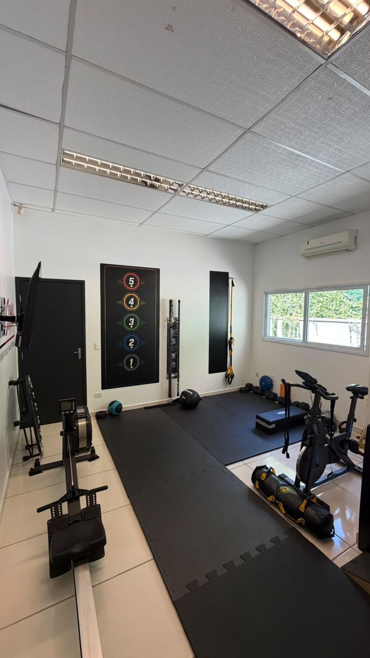 Sala de treino funcional com piso emborrachado e bicicleta