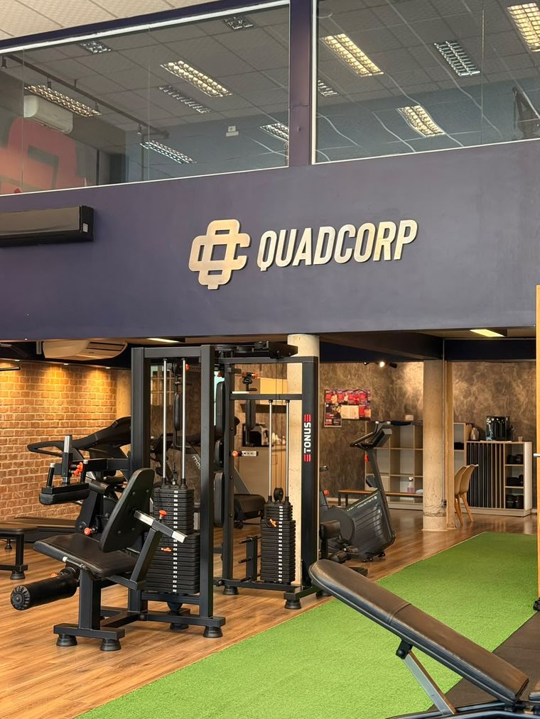 Parede marinho com o nome QuadCorp sobre a área de aparelhos